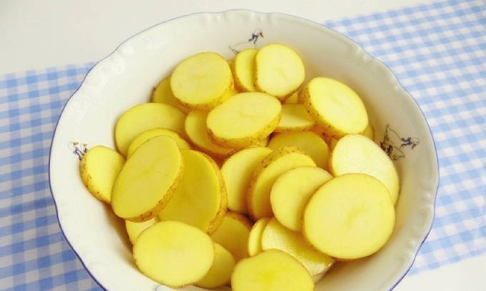 Die Kartoffeln in Scheiben schneiden